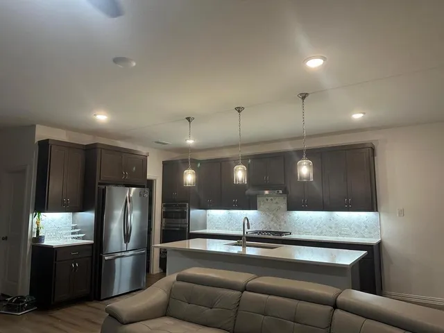 a view of kitchen with stainless steel appliances kitchen island a sink and a refrigerator