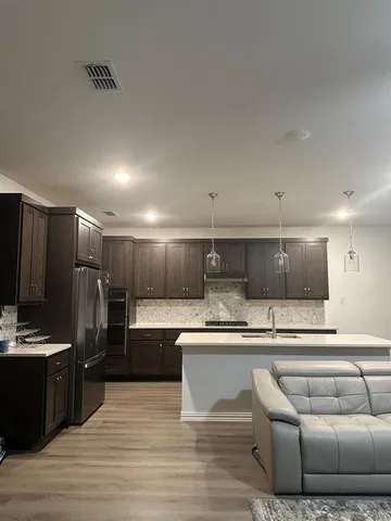 a kitchen with stainless steel appliances granite countertop a sink stove and refrigerator
