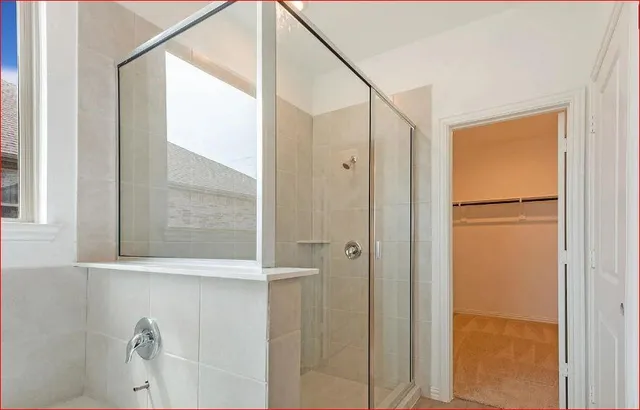 a bathroom with a shower and a glass door