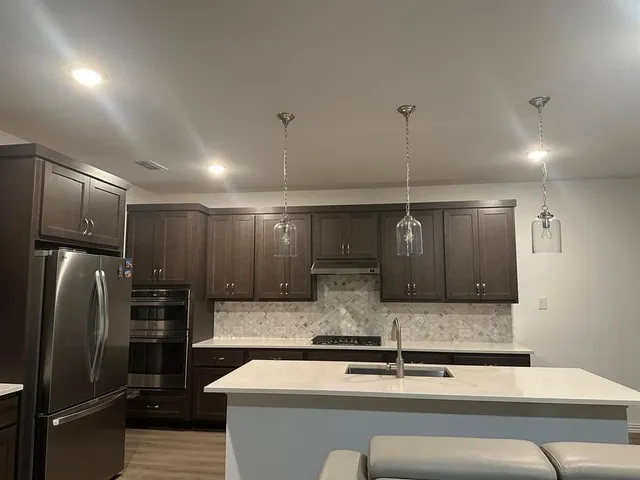 a kitchen with stainless steel appliances granite countertop a refrigerator and a sink