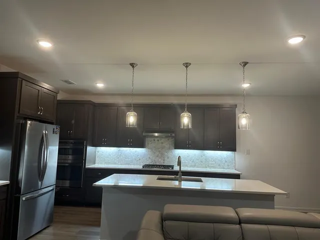 a view of kitchen with stainless steel appliances kitchen island a table and chairs