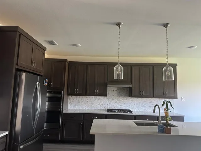 a living room with stainless steel appliances kitchen island granite countertop a sink and cabinets
