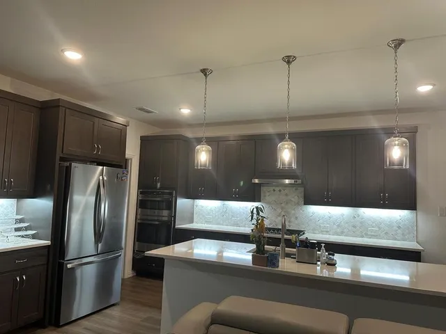 a kitchen with stainless steel appliances granite countertop a sink refrigerator and cabinets
