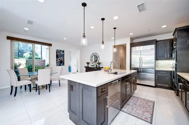 a kitchen with kitchen island granite countertop a sink a counter top space and a view of living room