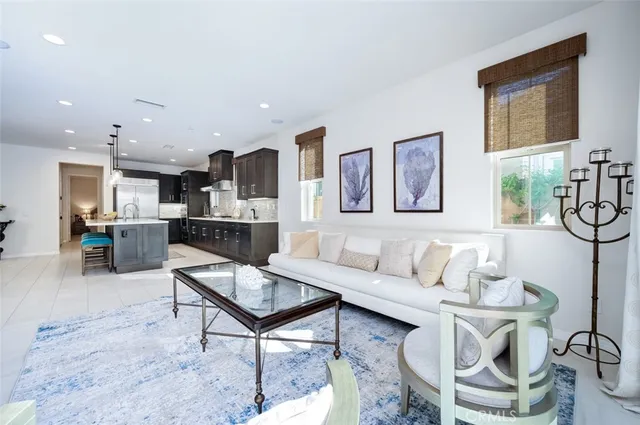 a living room with furniture a flat screen tv and kitchen view