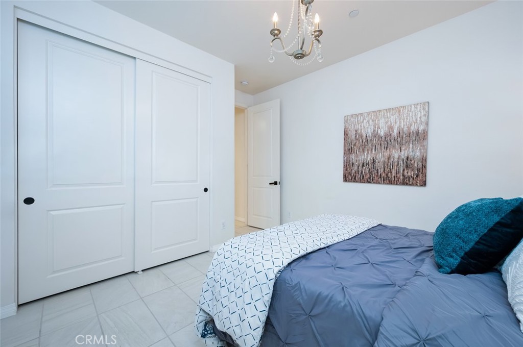 126 Brambles Irvine, CA 92618 - Photo 24 of 59 a bedroom with a bed and a chandelier