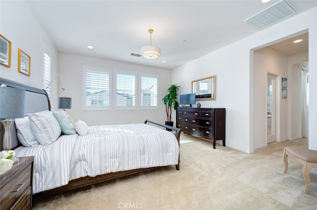 126 Brambles Irvine, CA 92618 - Photo 29 of 59 a bedroom with a bed and a chandelier