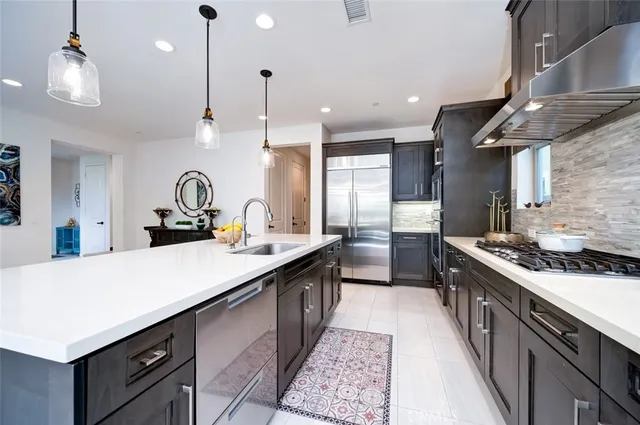 a kitchen with kitchen island a sink appliances and a counter top space