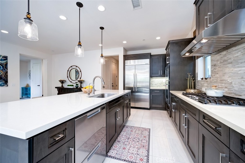 126 Brambles Irvine, CA 92618 - Photo 7 of 59 a kitchen with kitchen island a sink appliances and a counter top space