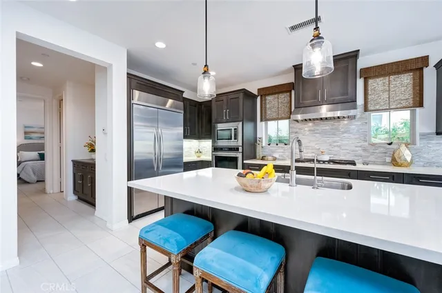 a kitchen with cabinets a sink and chairs in it