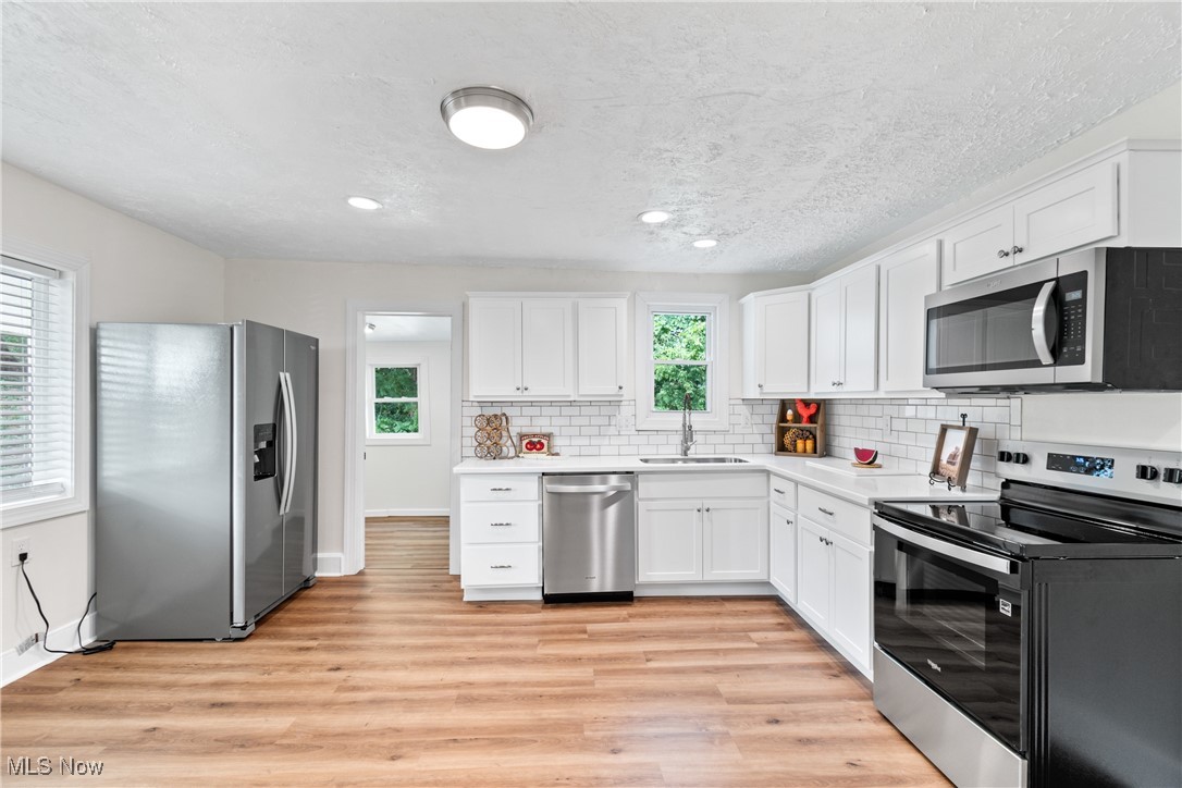 3516 Bair Road Northwest Dover, OH 44622 - Photo 13 of 29 View of kitchen area with stainless steel appliances and tiled backsplash