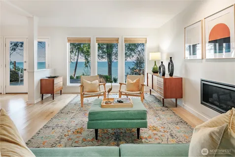 a living room with furniture a fireplace and large windows