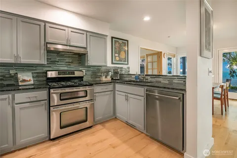 a kitchen with stainless steel appliances granite countertop a stove sink and cabinets
