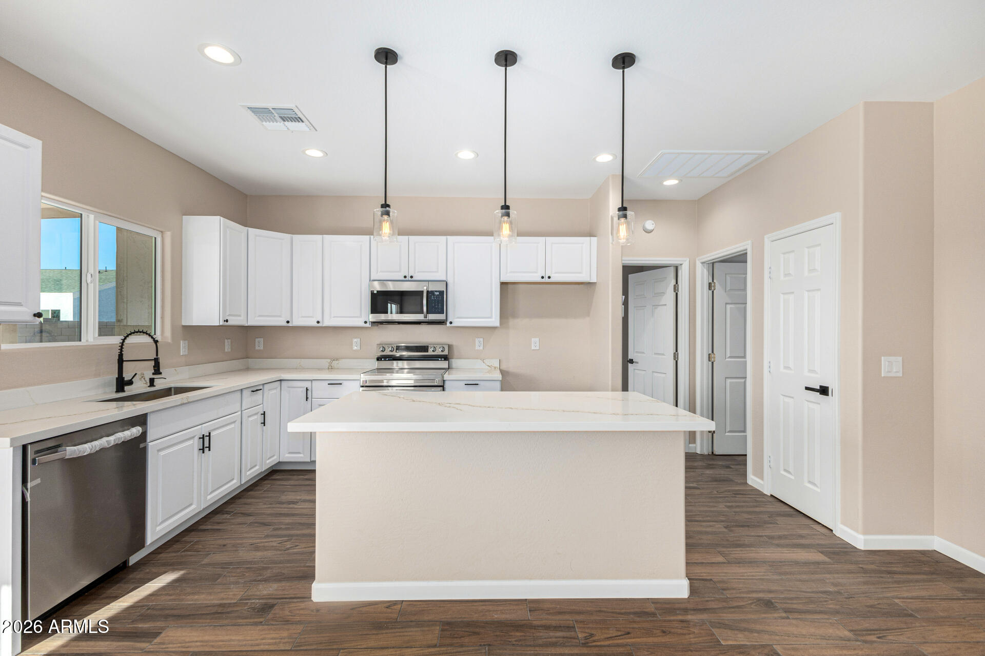 14058 South Tampico Road Arizona City, AZ 85123 - Photo 16 of 37 a large kitchen with stainless steel appliances granite countertop a sink a stove a refrigerator and white cabinets with wooden floor