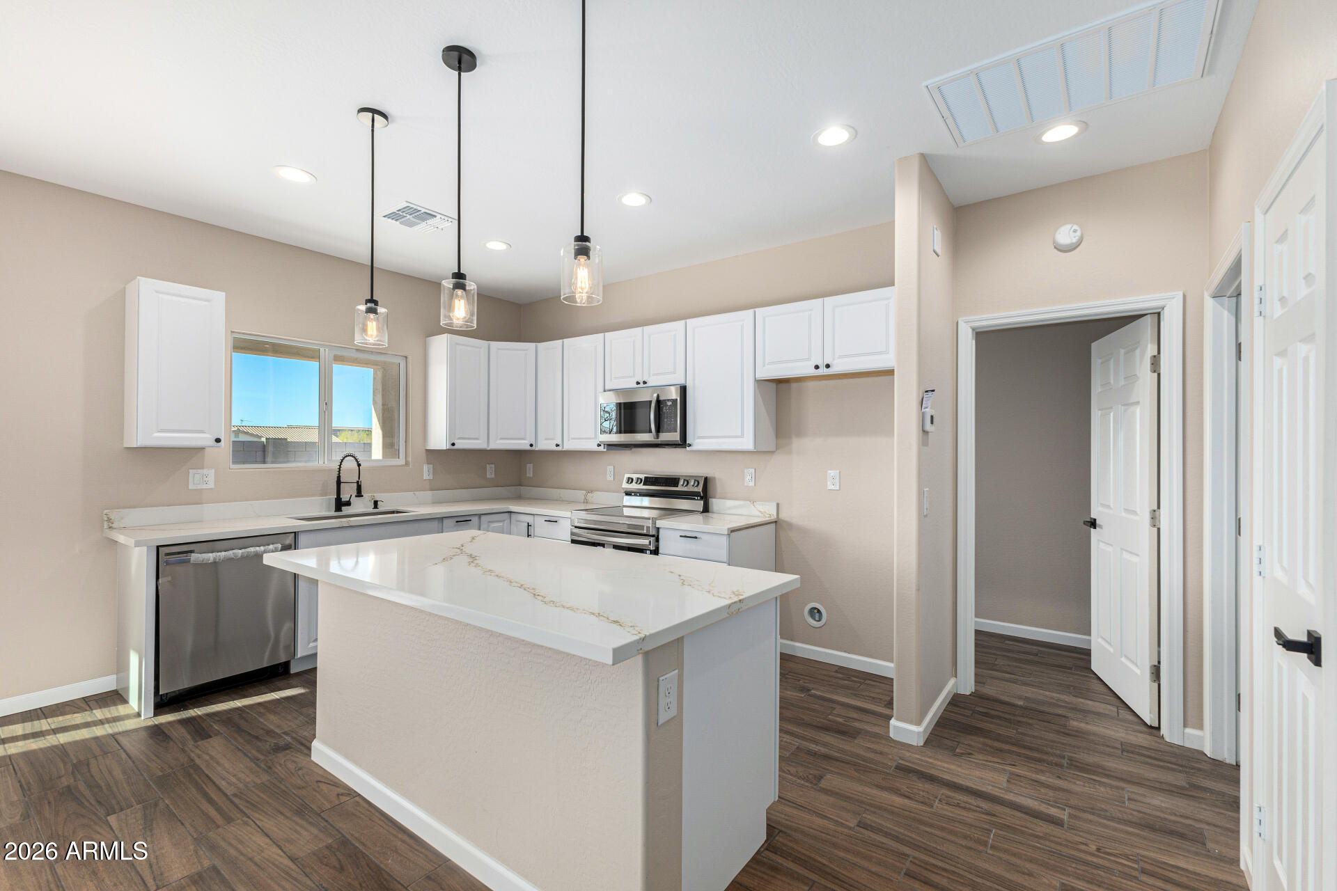 14058 South Tampico Road Arizona City, AZ 85123 - Photo 17 of 37 a kitchen with stainless steel appliances granite countertop a sink a stove a refrigerator and white cabinets with wooden floor