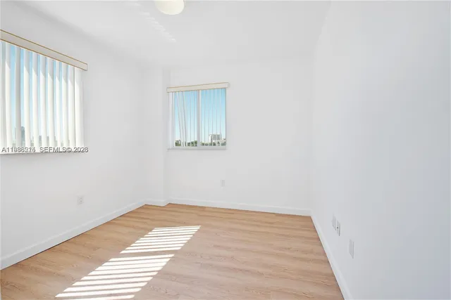 a view of a room with wooden floor and a window