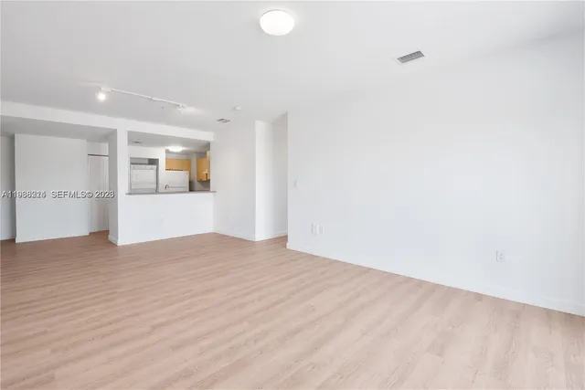 a view of empty room with wooden floor and windows