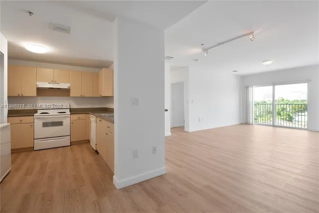 a kitchen with white cabinets and wooden floor