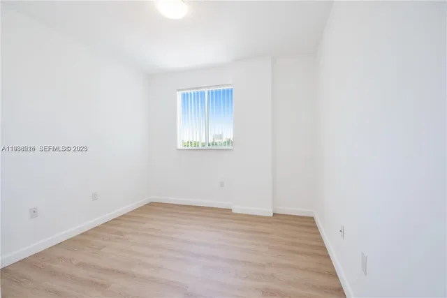 a view of a room with wooden floor and a window