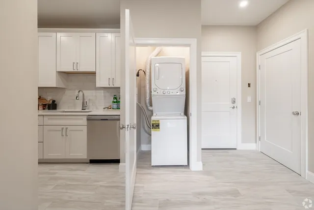 a kitchen with white cabinets and refrigerator