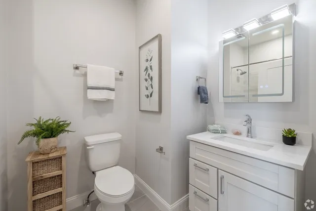 a bathroom with a toilet sink and mirror
