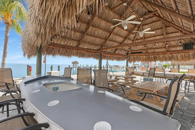 a kitchen with stainless steel appliances granite countertop a refrigerator a stove a sink a dining table and chairs with wooden floor