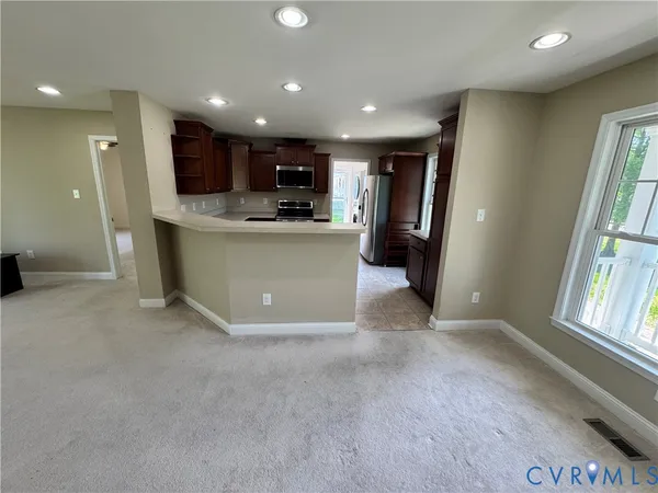 a view of kitchen with stainless steel appliances refrigerator stove microwave and cabinets
