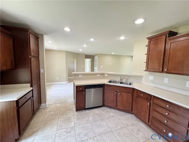a large kitchen with stainless steel appliances granite countertop a sink and dishwasher a oven with wooden cabinets
