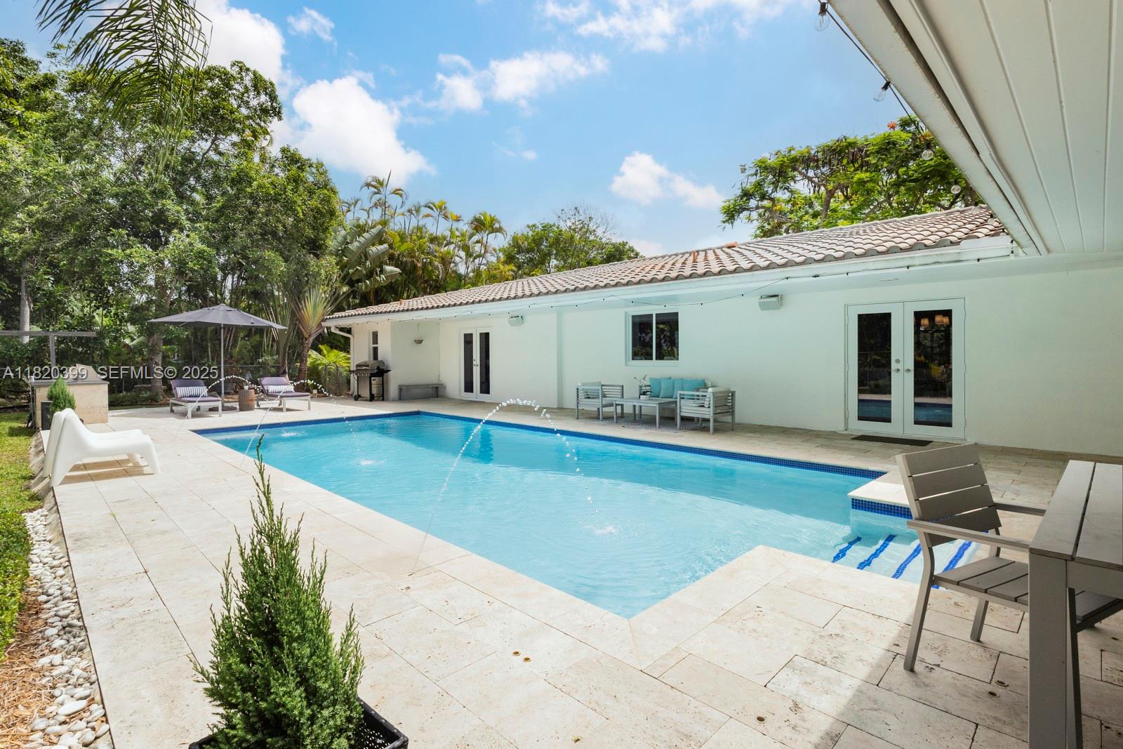 11900 Southwest 72nd Place Pinecrest, FL 33156 - Photo 16 of 37 a view of a house with swimming pool and sitting area