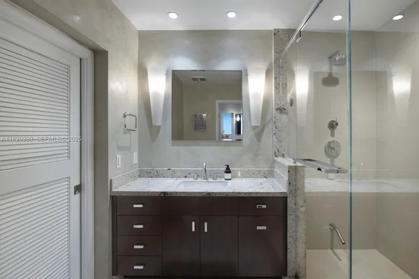 a bathroom with a double vanity sink mirror and shower