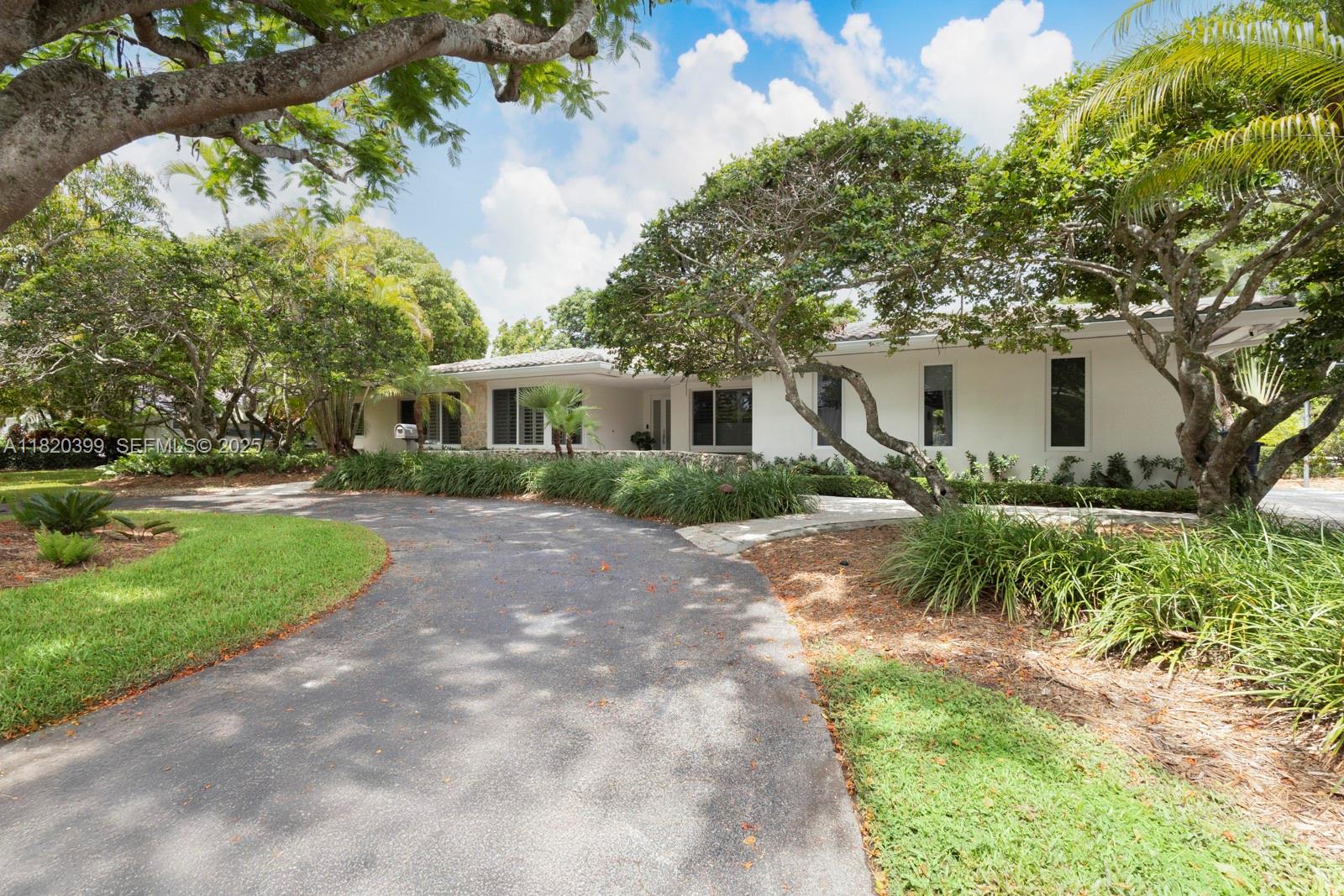 11900 Southwest 72nd Place Pinecrest, FL 33156 - Photo 2 of 37 a front view of a house with a yard