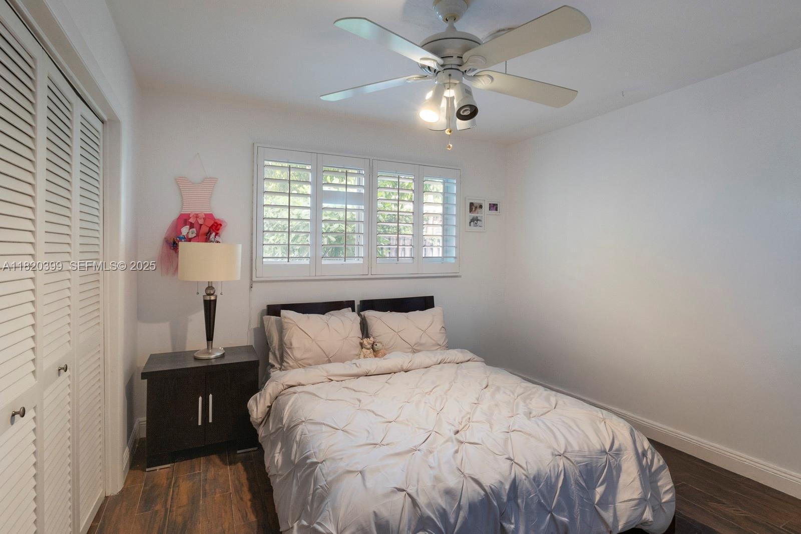 11900 Southwest 72nd Place Pinecrest, FL 33156 - Photo 23 of 37 a bedroom with a bed and wooden floor