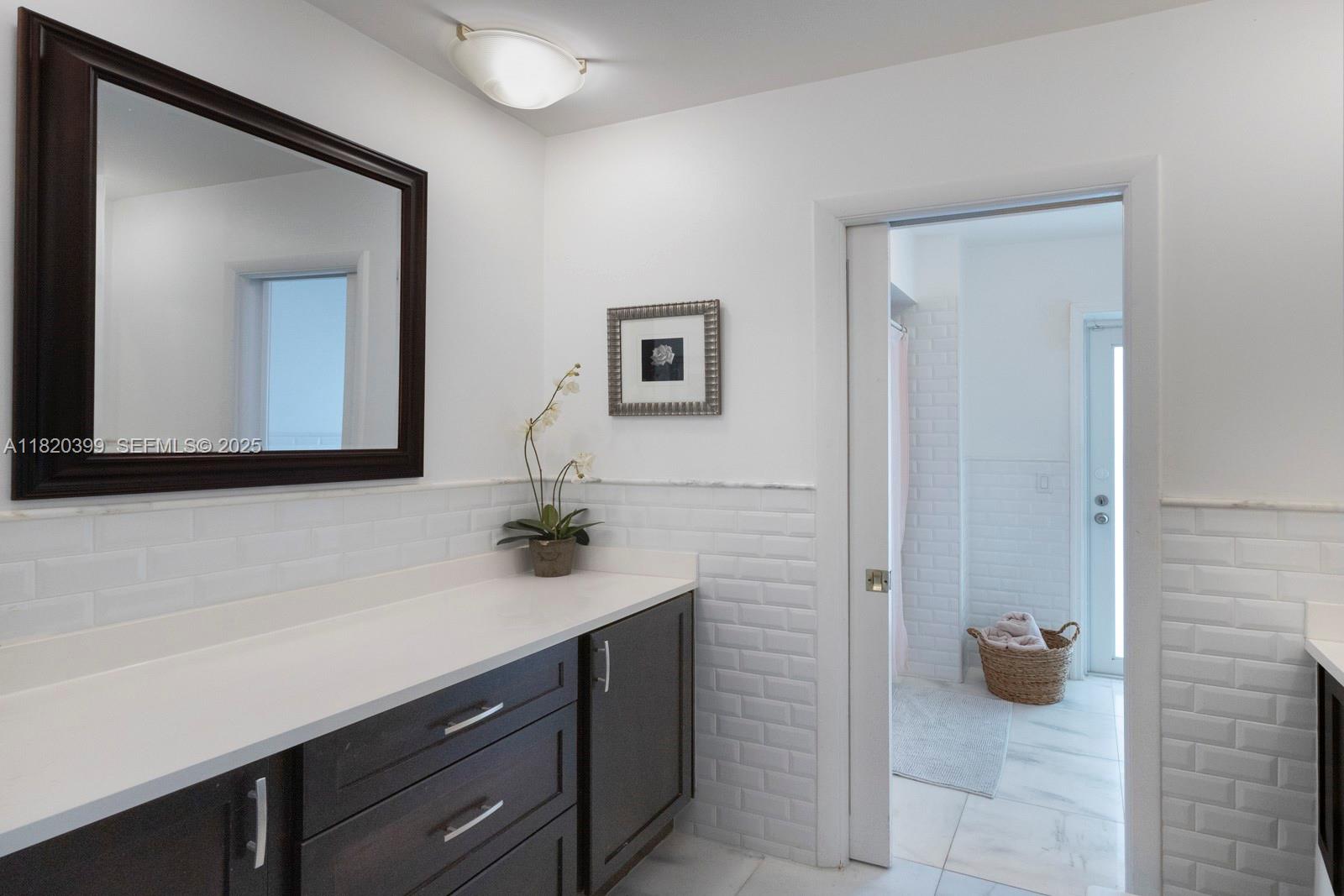 11900 Southwest 72nd Place Pinecrest, FL 33156 - Photo 24 of 37 a bathroom with a sink a mirror and vanity