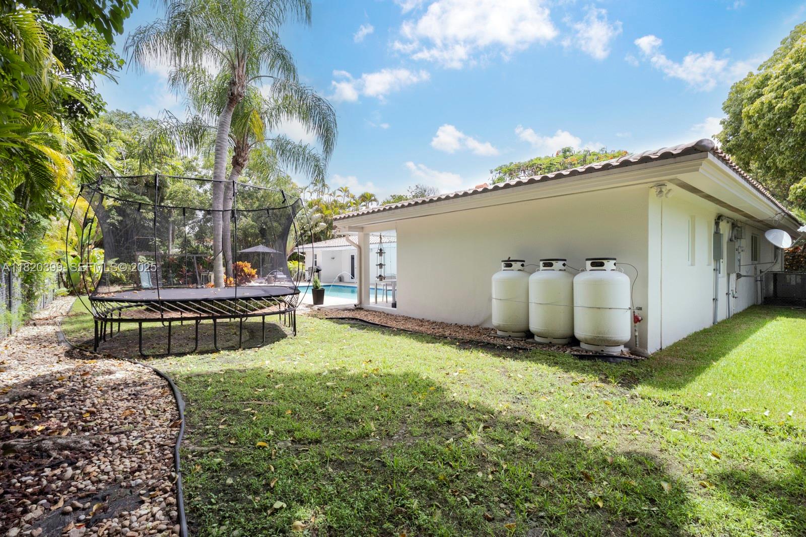 11900 Southwest 72nd Place Pinecrest, FL 33156 - Photo 29 of 37 a backyard of a house with table and chairs