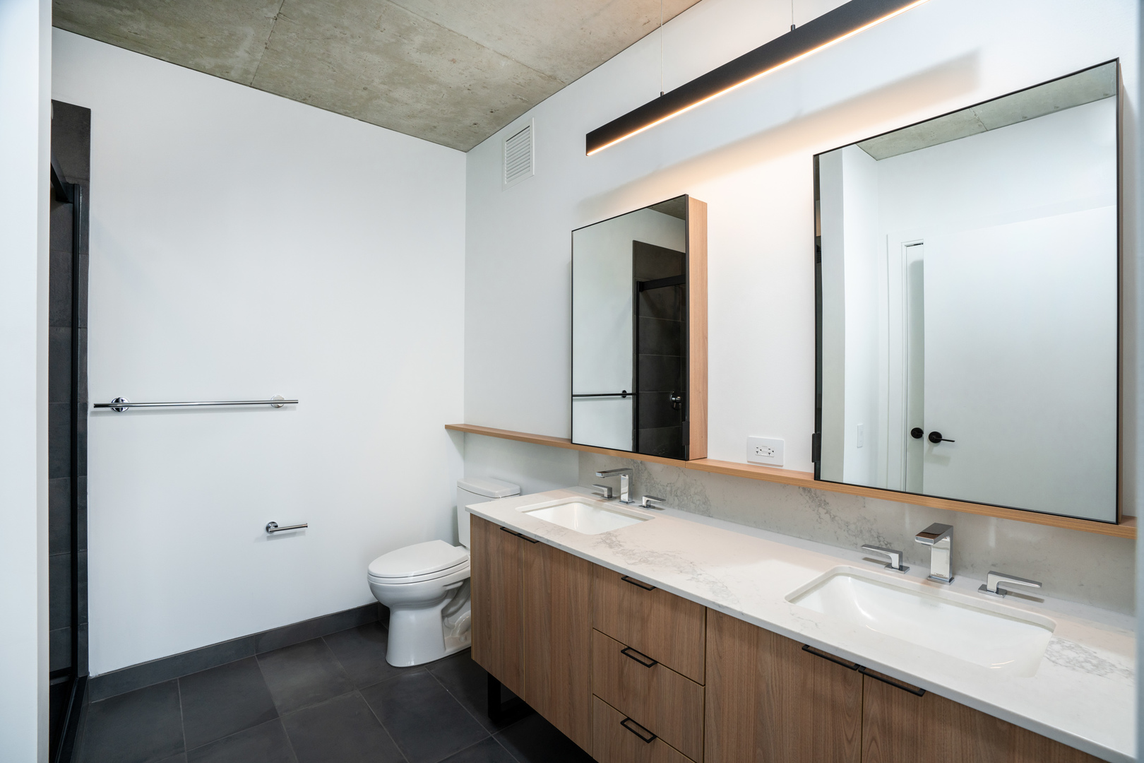234 West Polk Street, Unit 3701 Chicago, IL 60607 - Photo 10 of 32 a bathroom with a double vanity sink toilet and mirror