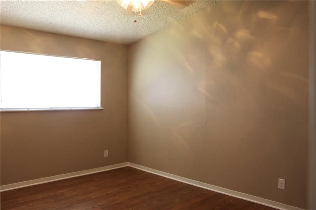 606 West 51st Street, Unit 104 Austin, TX 78751 - Photo 11 of 21 Unfurnished room with a textured ceiling, dark wood-style flooring, and a ceiling fan