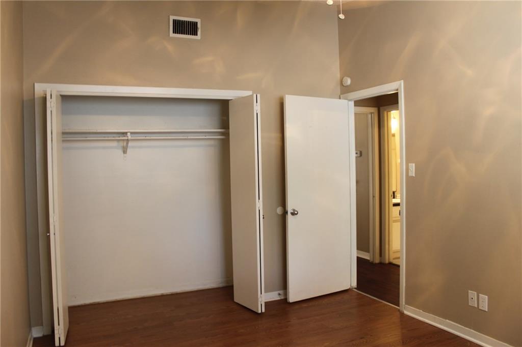 606 West 51st Street, Unit 104 Austin, TX 78751 - Photo 12 of 21 Unfurnished bedroom with dark wood-style flooring and a closet