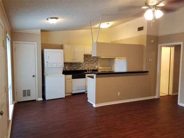 a view of a kitchen with a sink and a refrigerator