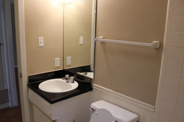 a bathroom with a sink toilet and mirror