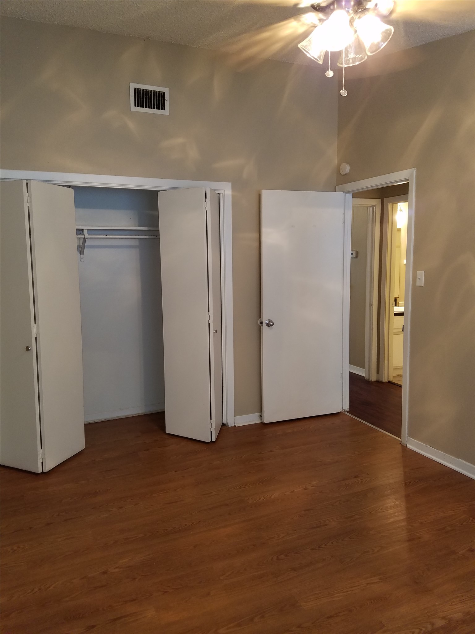 606 West 51st Street, Unit 104 Austin, TX 78751 - Photo 18 of 21 Unfurnished bedroom with a closet, dark wood-style floors, and a ceiling fan