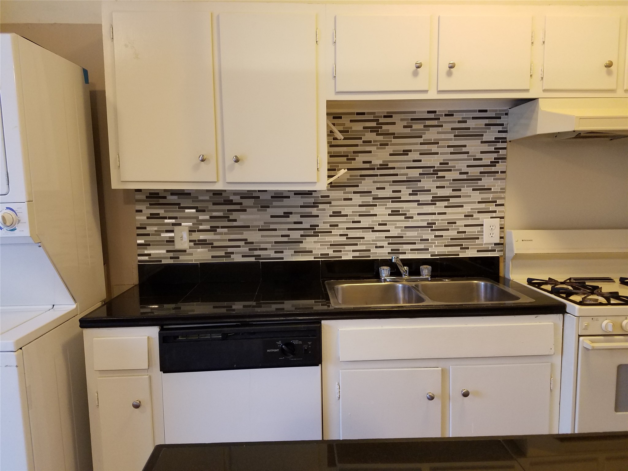 606 West 51st Street, Unit 104 Austin, TX 78751 - Photo 2 of 21 Kitchen featuring dark countertops, white appliances, and white cabinetry