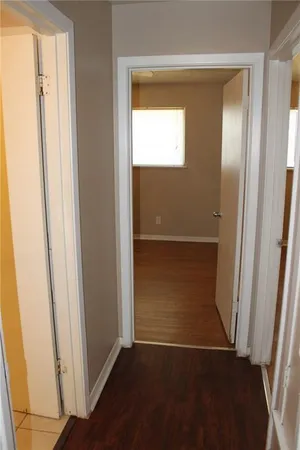 an empty room with wooden floor door and windows