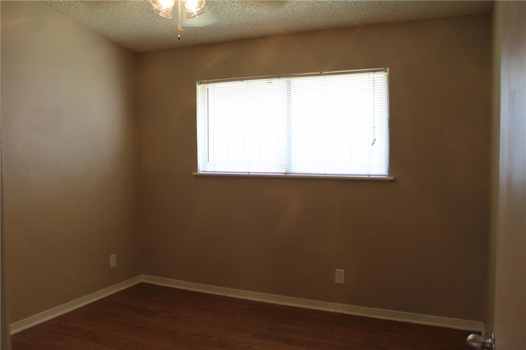 606 West 51st Street, Unit 104 Austin, TX 78751 - Photo 9 of 21 Spare room with a textured ceiling, ceiling fan, and dark wood-style flooring