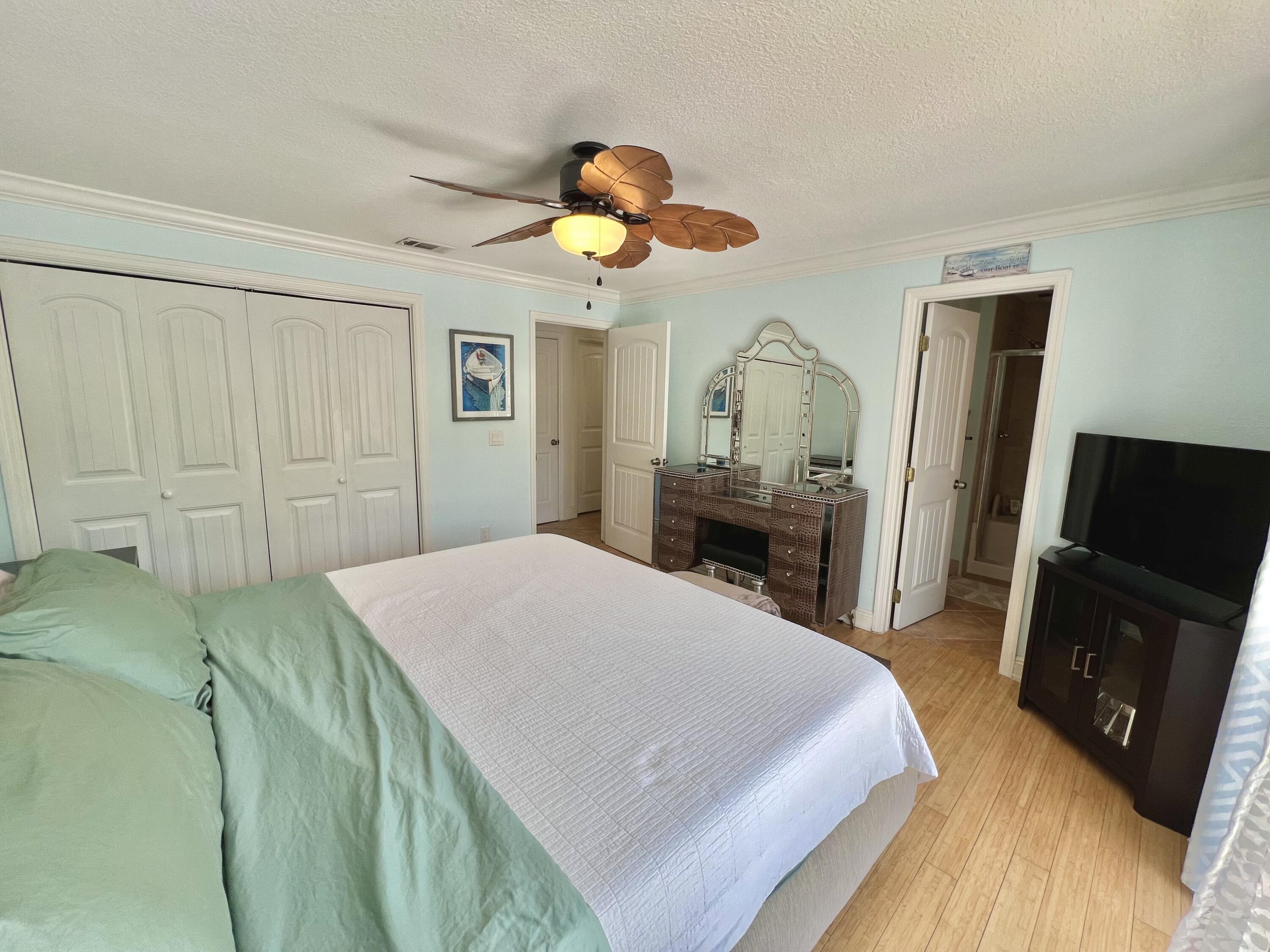 24 Bounty Lane Key Largo, FL 33037 - Photo 15 of 36 a bedroom with a bed and a flat tv screen on dresser