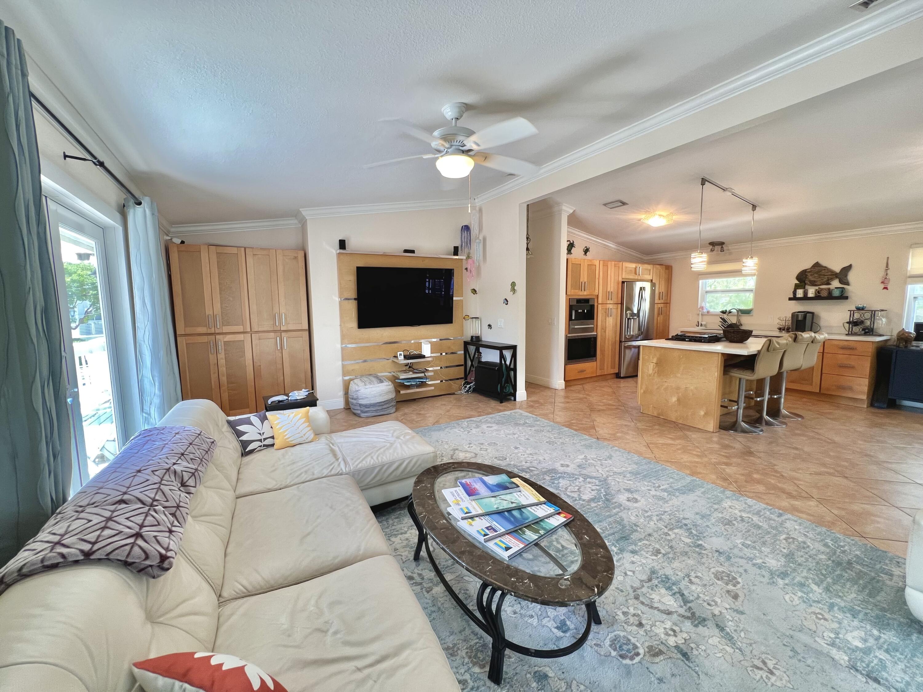 24 Bounty Lane Key Largo, FL 33037 - Photo 8 of 36 a living room with furniture a flat screen tv and a large window