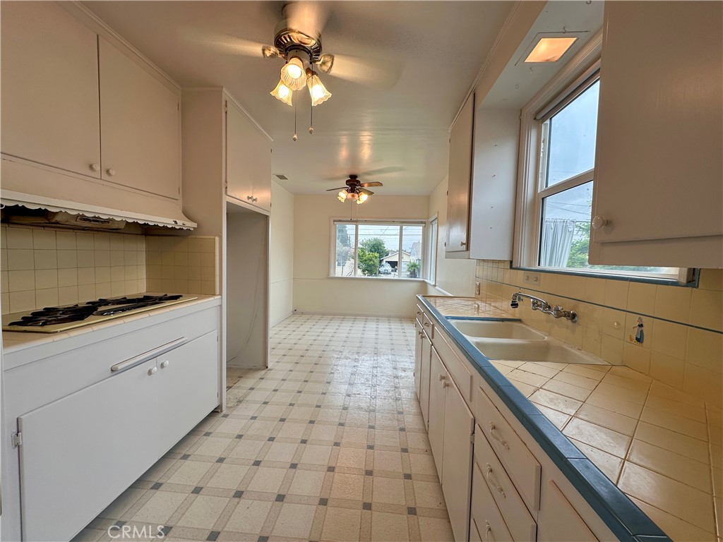 823 Edith Avenue Alhambra, CA 91803 - Photo 33 of 46 a kitchen with a sink a stove cabinets and black appliances