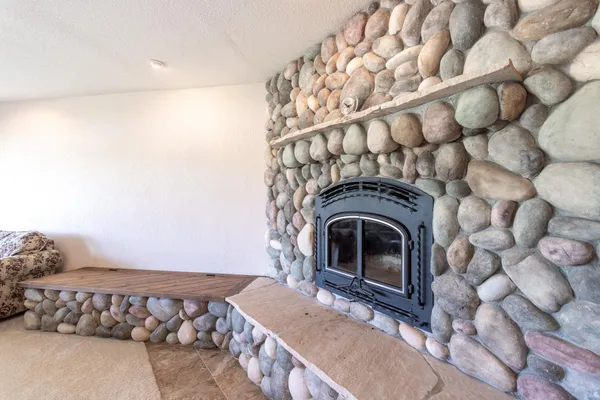 a bedroom with a large bed and a chandelier fan