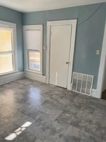 an empty room with windows and closet