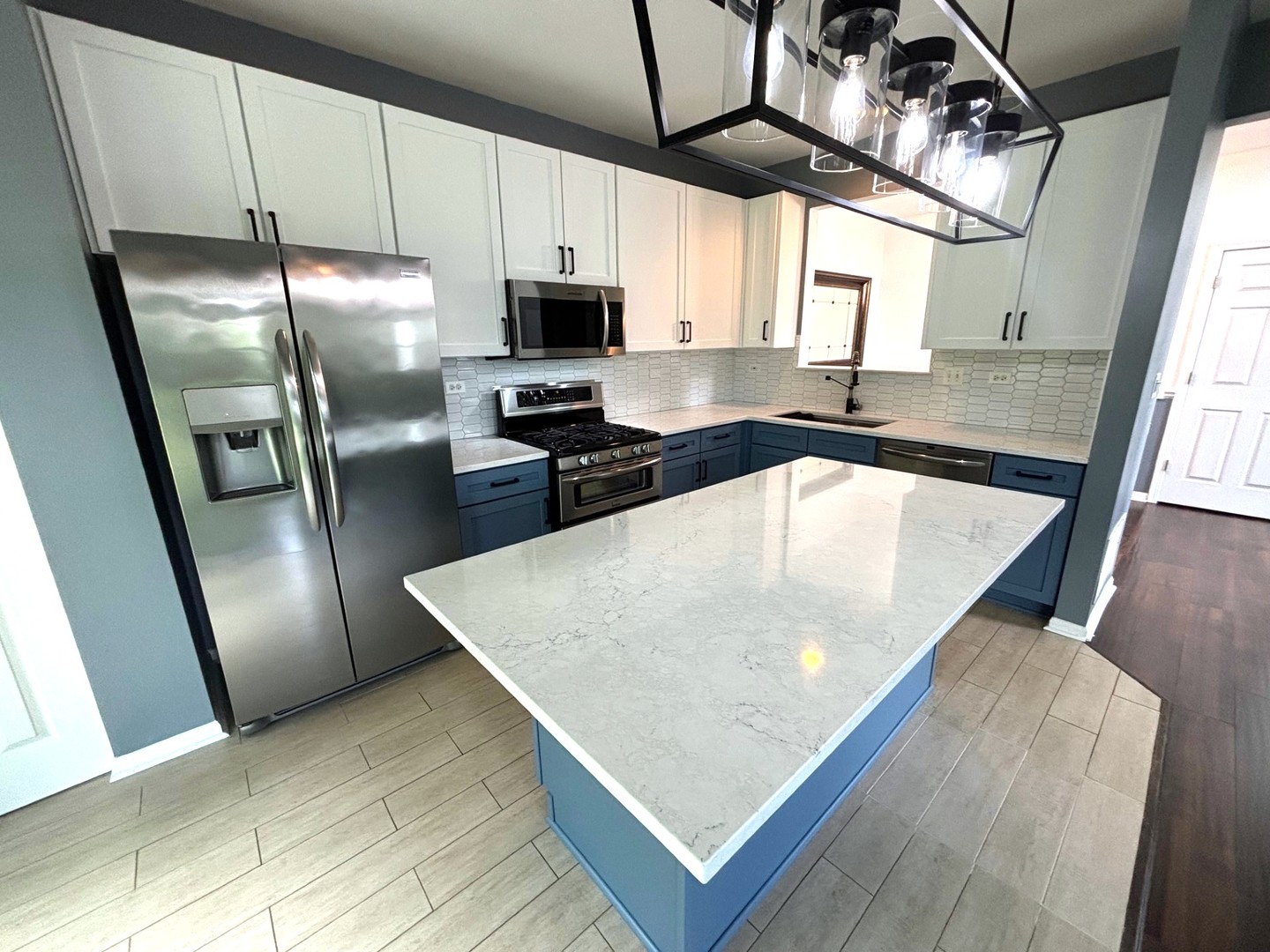 2468 Reflections Drive Aurora, IL 60502 - Photo 17 of 44 a kitchen with stainless steel appliances granite countertop a sink a refrigerator island white cabinetry and a sink