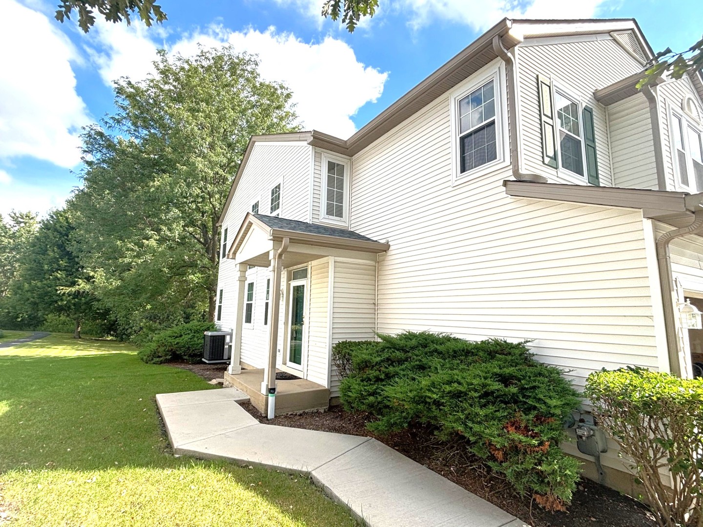 2468 Reflections Drive Aurora, IL 60502 - Photo 2 of 44 a view of a white house with a small yard plants and a large tree